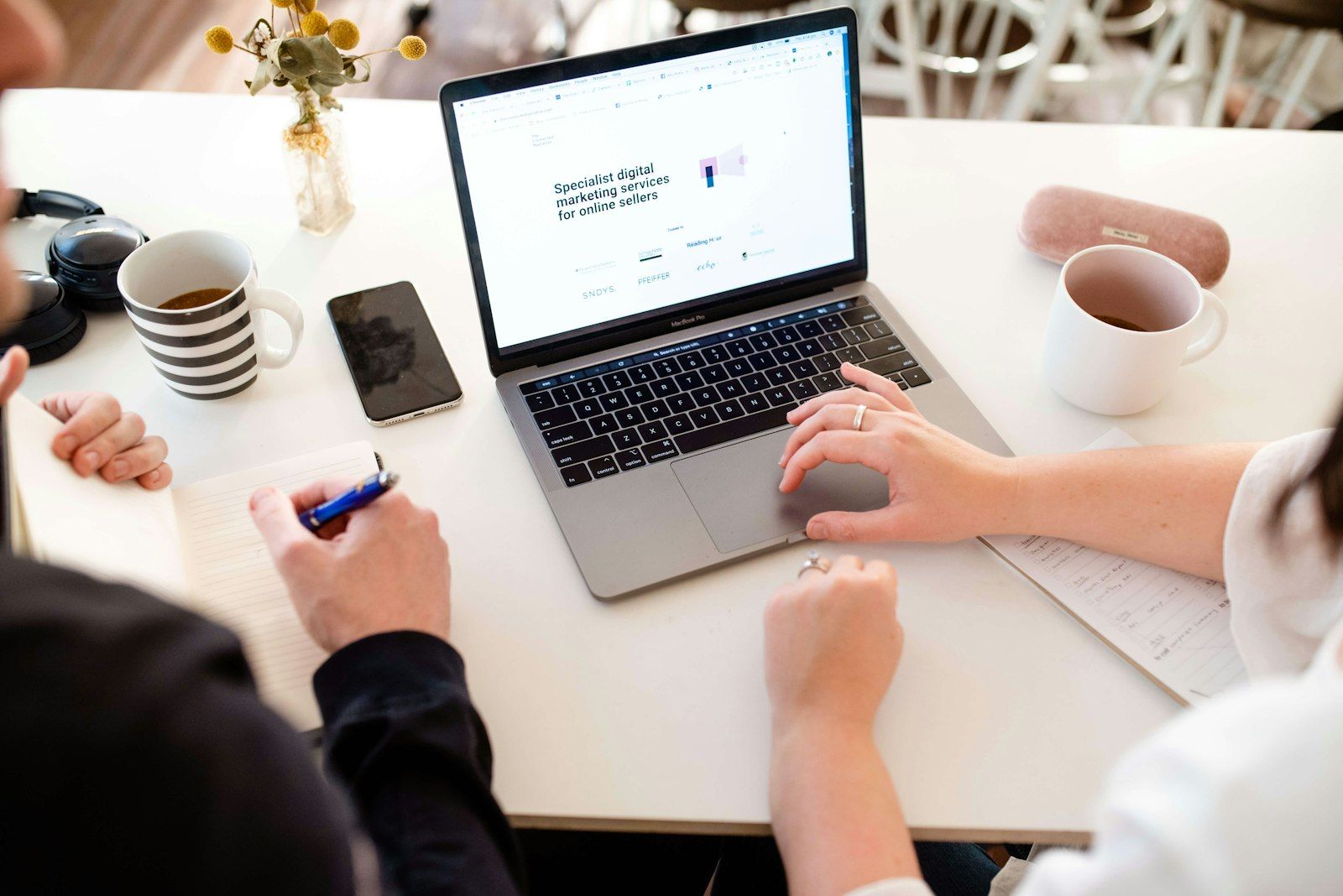 Twee mensen werken samen aan een website op een laptop