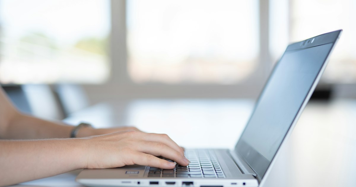 Iemand typt op een laptop tijdens het vertalen van een website